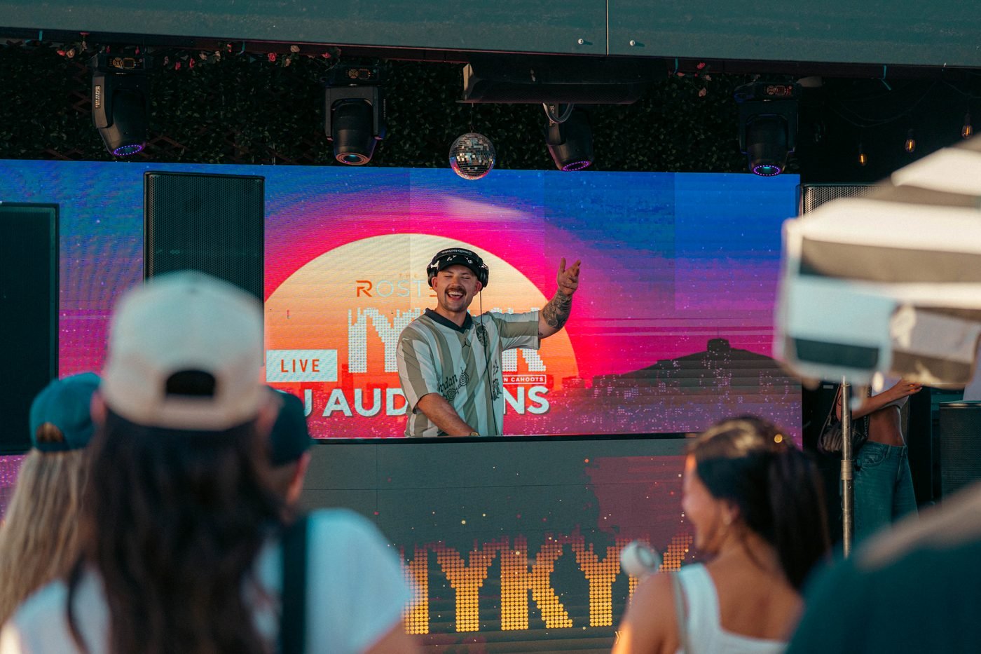 B.Y. waving to the crowd from behind the decks.